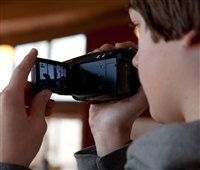 A picture showing a boy recording a video